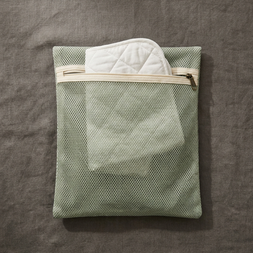 The BESIDE Wash Bag, a sage mesh laundry bag sized for a layer